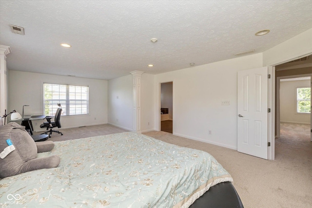 12772 Tram Ln, Carmel, IN 46032 - bedroom with light colored carpet, decorative columns, a textured ceiling, and recessed lighting