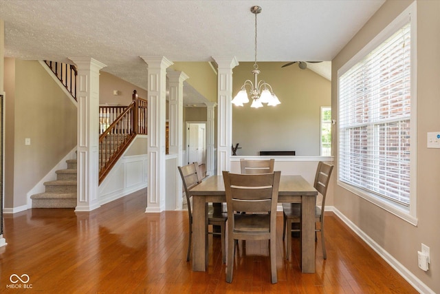 12772 Tram Ln, Carmel, IN 46032 - dining room with wood-type flooring, stairway, ornate columns, lofted ceiling, and a chandelier
