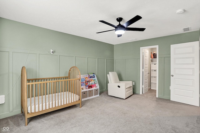 9716 Cimmaron Ave, Mccordsville, IN 46055 - bedroom with a decorative wall, carpet, a crib, wainscoting, and ceiling fan