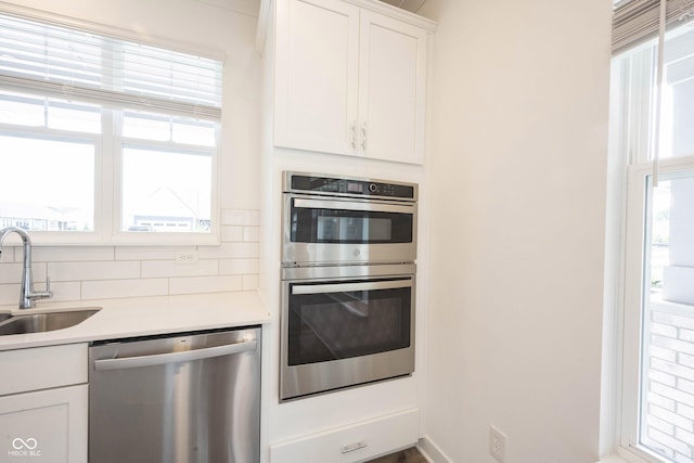 19800 Sutton Ter, Westfield, IN 46074 - kitchen featuring appliances with stainless steel finishes, a sink, decorative backsplash, white cabinets, and light countertops