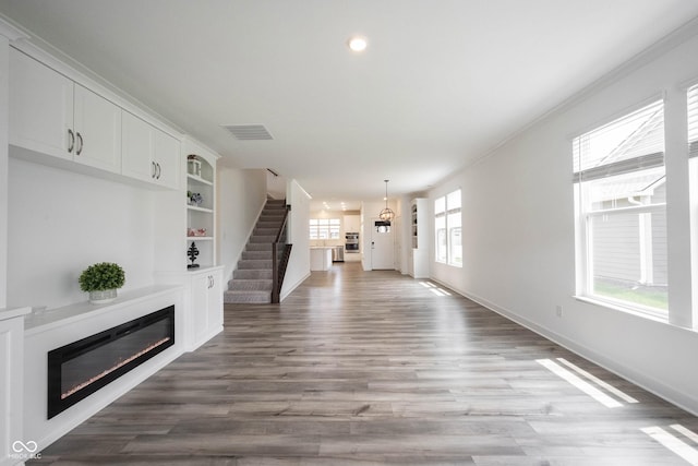 19800 Sutton Ter, Westfield, IN 46074 - unfurnished living room with a glass covered fireplace, wood finished floors, baseboards, ornamental molding, and recessed lighting