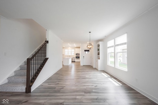 19800 Sutton Ter, Westfield, IN 46074 - unfurnished dining area with a chandelier, stairway, light wood-style floors, and baseboards