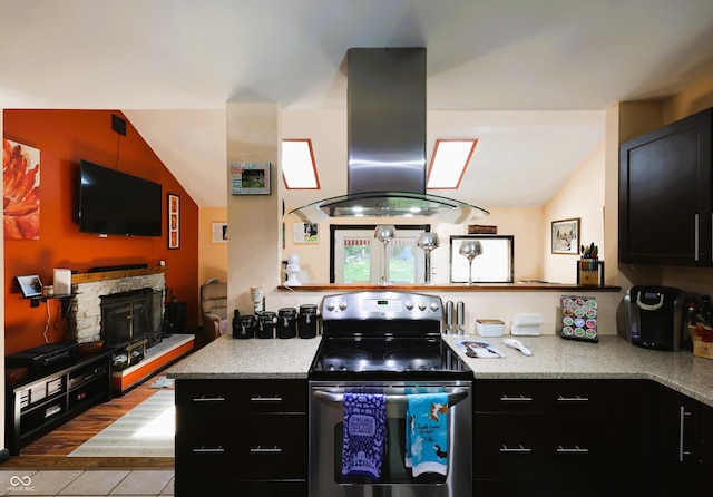 5654 Paradise Dr, Martinsville, IN 46151 - kitchen with stainless steel range with electric cooktop, exhaust hood, dark cabinetry, tile patterned floors, and lofted ceiling