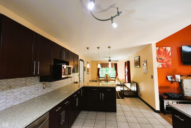 5654 Paradise Dr, Martinsville, IN 46151 - kitchen with stainless steel microwave, decorative backsplash, light stone counters, a peninsula, and light tile patterned flooring