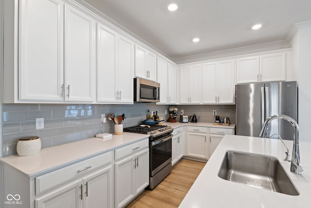 14848 Stonneger St, Westfield, IN 46074 - kitchen with appliances with stainless steel finishes, a sink, white cabinets, light countertops, and light wood finished floors