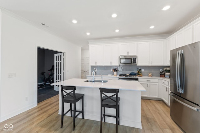 14848 Stonneger St, Westfield, IN 46074 - kitchen featuring stainless steel appliances, a sink, a kitchen island with sink, backsplash, and a breakfast bar