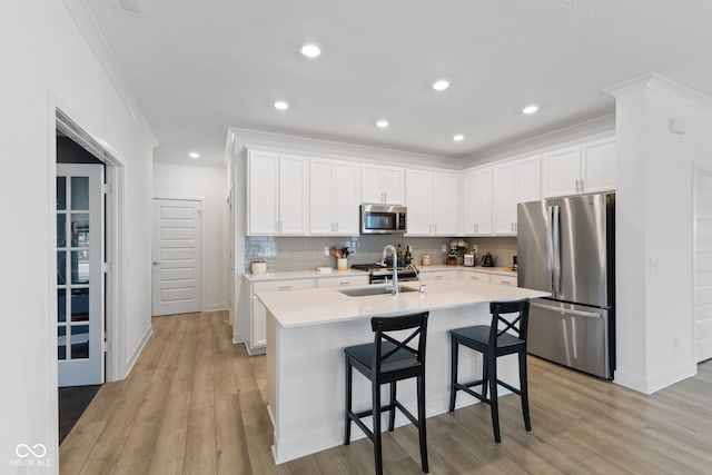 14848 Stonneger St, Westfield, IN 46074 - kitchen featuring stainless steel appliances, ornamental molding, light countertops, tasteful backsplash, and a kitchen island with sink