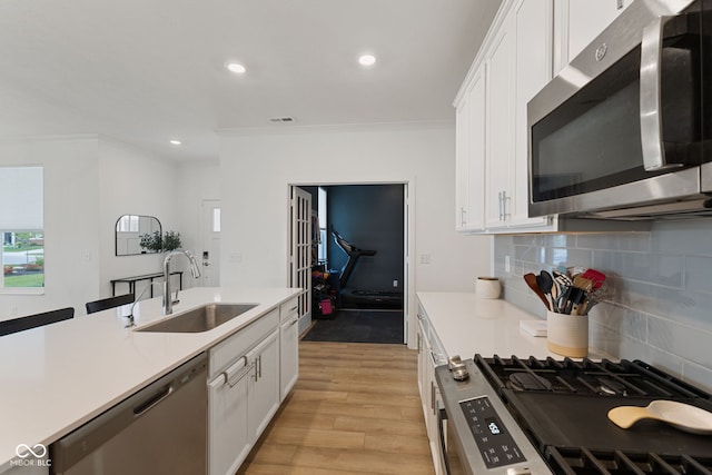 14848 Stonneger St, Westfield, IN 46074 - kitchen with appliances with stainless steel finishes, a sink, white cabinets, decorative backsplash, and light countertops