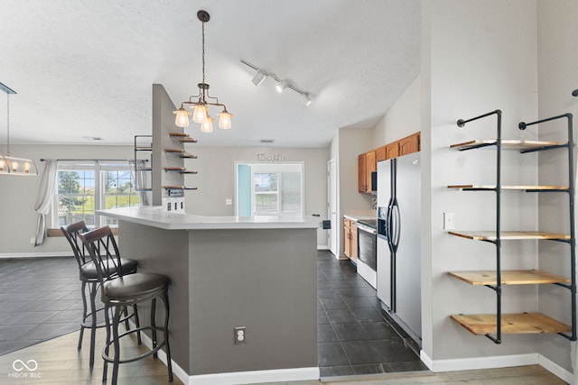 10693 Newgate Ln, Indianapolis, IN 46231 - kitchen with a chandelier, brown cabinets, a kitchen breakfast bar, fridge with ice dispenser, and light countertops
