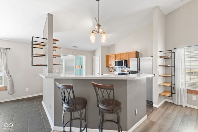 10693 Newgate Ln, Indianapolis, IN 46231 - kitchen featuring stainless steel fridge, light countertops, a chandelier, lofted ceiling, and range
