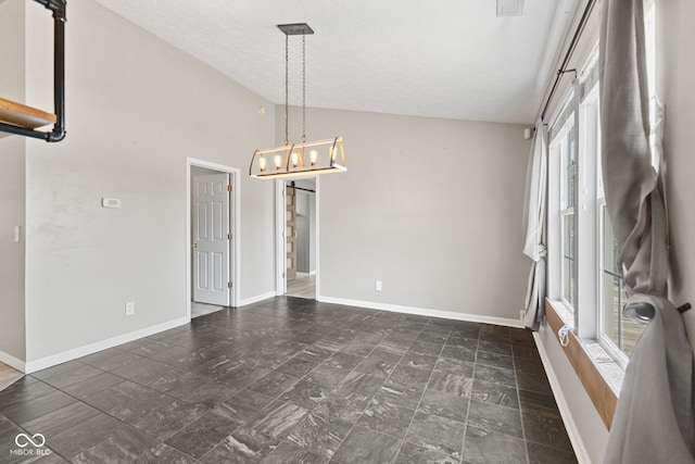10693 Newgate Ln, Indianapolis, IN 46231 - empty room with lofted ceiling, baseboards, stone finish floors, and a chandelier