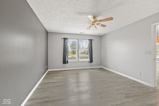 10693 Newgate Ln, Indianapolis, IN 46231 - empty room with a ceiling fan, a textured ceiling, wood finished floors, and baseboards