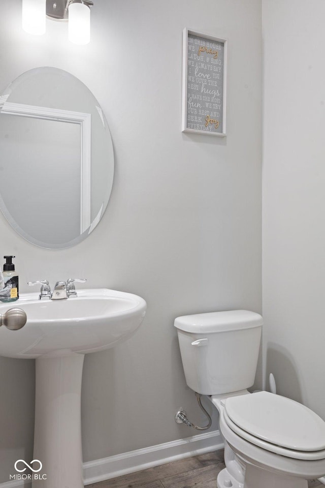 7834 Fairwood Blvd, Plainfield, IN 46168 - half bath featuring toilet, baseboards, wood finished floors, and a sink