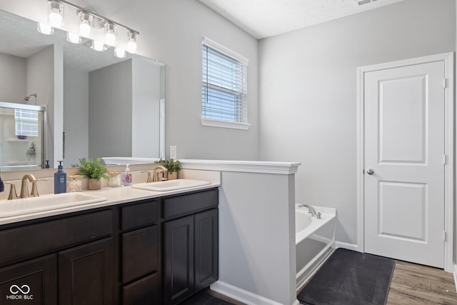 7834 Fairwood Blvd, Plainfield, IN 46168 - full bathroom featuring a garden tub, double vanity, wood finished floors, and an enclosed shower