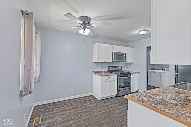3898 S Randolph St, Indianapolis, IN 46227 - kitchen with appliances with stainless steel finishes, separate washer and dryer, white cabinetry, and ceiling fan
