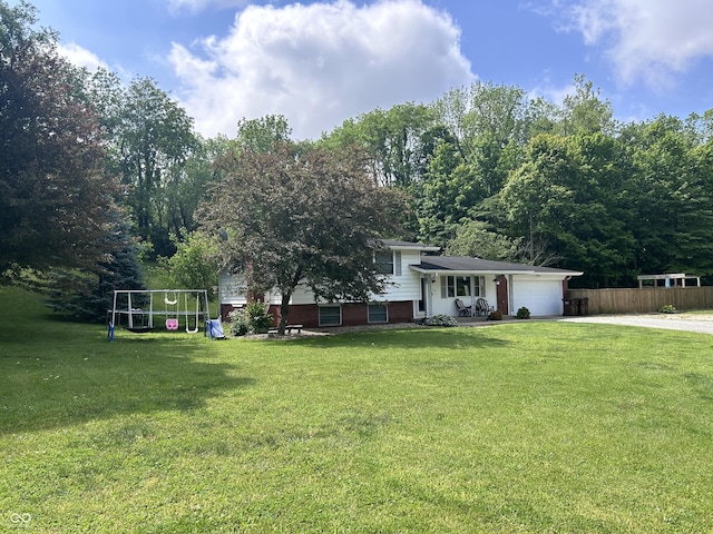 5174 S Greensboro Pike, Knightstown, IN 46148 - view of yard with driveway, an attached garage, and a playground