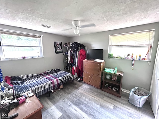 5174 S Greensboro Pike, Knightstown, IN 46148 - bedroom featuring wood finished floors, multiple windows, a textured ceiling, and a ceiling fan