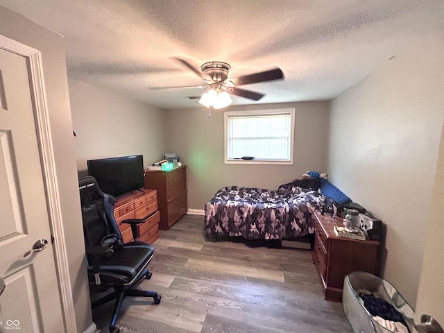 5174 S Greensboro Pike, Knightstown, IN 46148 - bedroom with wood finished floors, a textured ceiling, a desk, and a ceiling fan