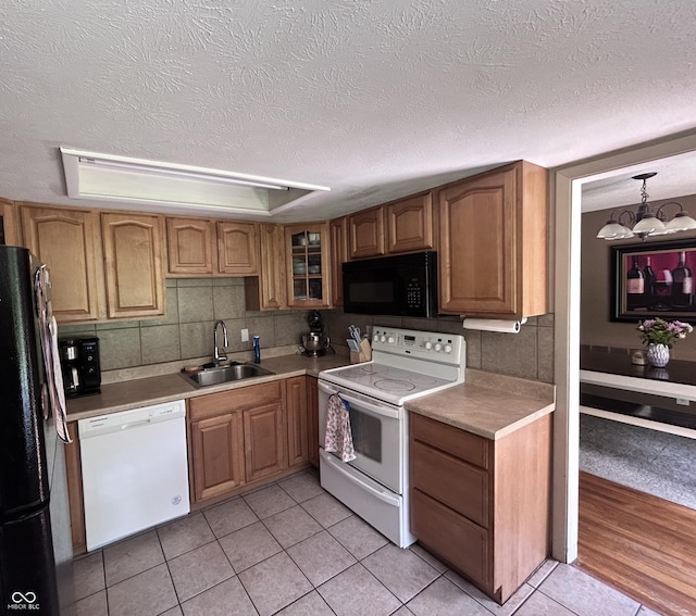 5174 S Greensboro Pike, Knightstown, IN 46148 - kitchen featuring black appliances, a sink, light tile patterned floors, brown cabinets, and a chandelier