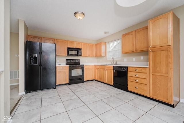5258 Brassie Dr, Indianapolis, IN 46235 - kitchen with black appliances, light countertops, a sink, light brown cabinetry, and light tile patterned floors
