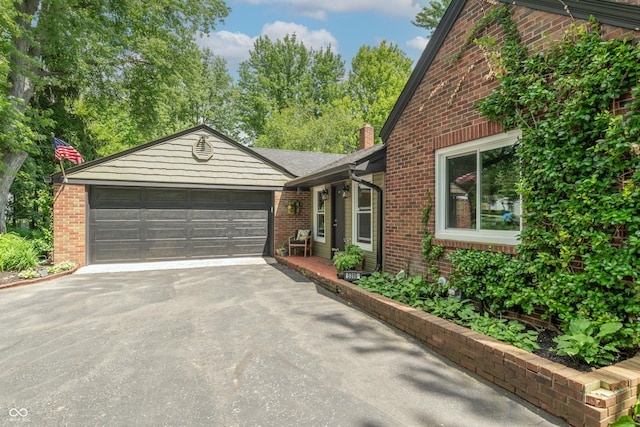 5315 Camden St, Indianapolis, IN 46227 - view of property exterior with driveway, a garage, brick siding, and a chimney