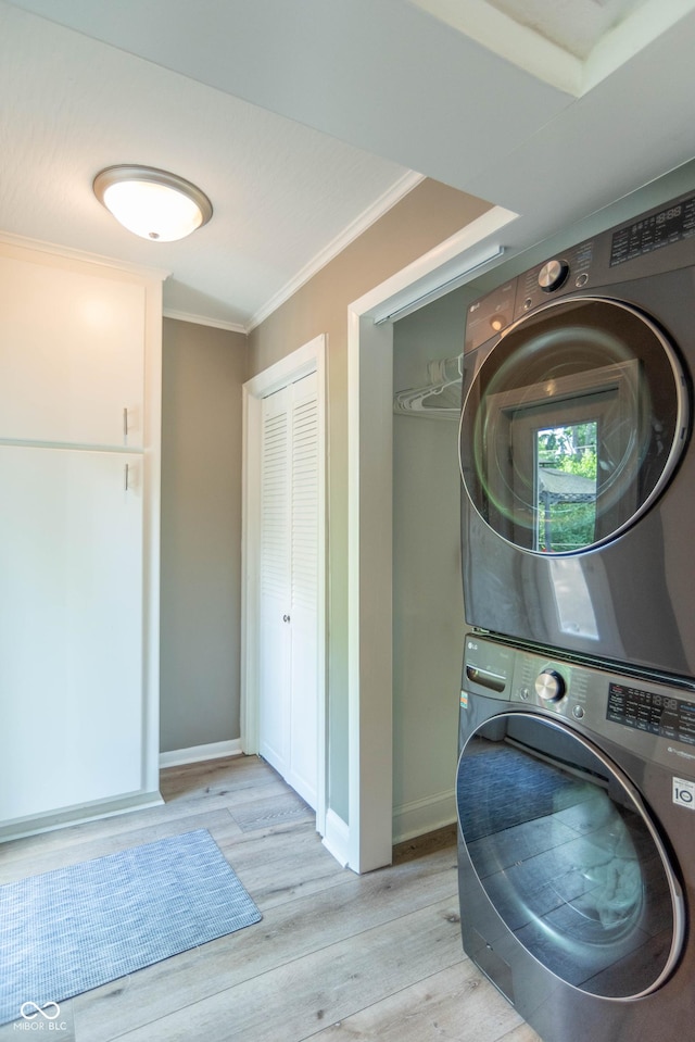 5315 Camden St, Indianapolis, IN 46227 - washroom featuring stacked washing machine and dryer, crown molding, light wood-style floors, and baseboards