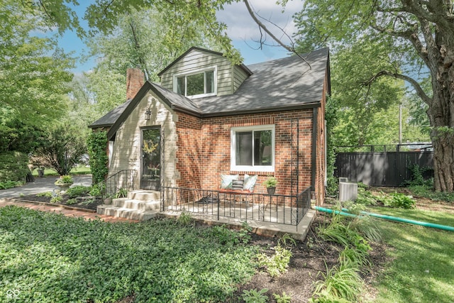 5315 Camden St, Indianapolis, IN 46227 - view of front of house with brick siding, a chimney, roof with shingles, and cooling unit