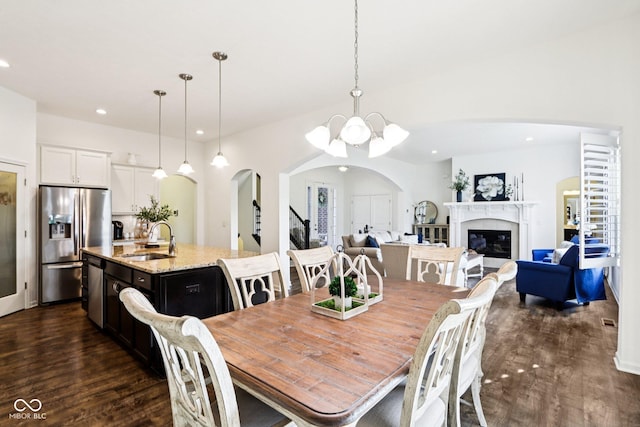 1521 Avondale Dr, Westfield, IN 46074 - dining area with arched walkways, a chandelier, dark wood-style flooring, recessed lighting, and a glass covered fireplace