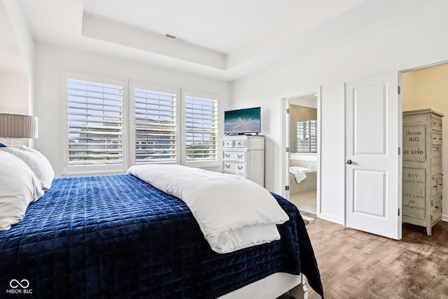 1521 Avondale Dr, Westfield, IN 46074 - bedroom featuring light wood-style flooring, a tray ceiling, and ensuite bathroom