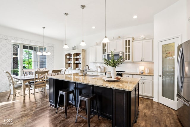 1521 Avondale Dr, Westfield, IN 46074 - kitchen featuring appliances with stainless steel finishes, white cabinetry, dark wood-style floors, decorative backsplash, and a breakfast bar area