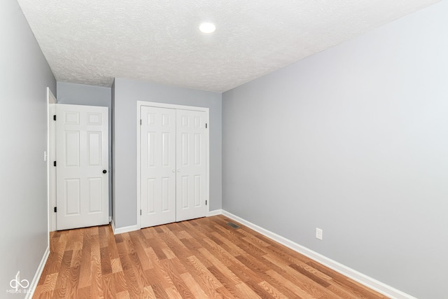 8445 Montery Rd, Indianapolis, IN 46226 - unfurnished bedroom featuring baseboards, a textured ceiling, light wood-style floors, a closet, and recessed lighting