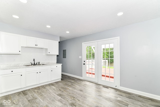 8445 Montery Rd, Indianapolis, IN 46226 - kitchen with a sink, light wood-style floors, light countertops, baseboards, and white cabinets