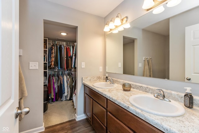 929 Capricorn Dr, Franklin, IN 46131 - full bathroom with wood finished floors, double vanity, a walk in closet, and baseboards