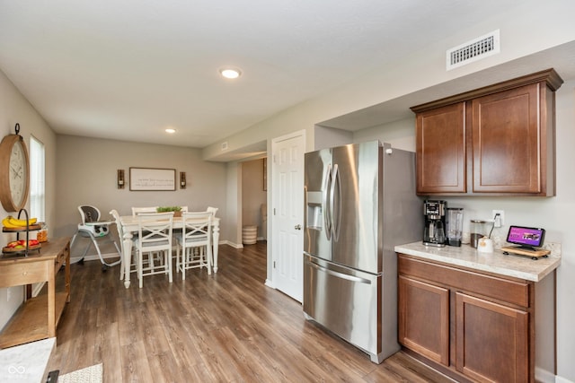 929 Capricorn Dr, Franklin, IN 46131 - kitchen with stainless steel fridge with ice dispenser, light countertops, wood finished floors, recessed lighting, and brown cabinets