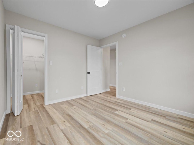 31 Mckenzie St, Shelbyville, IN 46176 - unfurnished bedroom with light wood-style floors, a walk in closet, baseboards, and a closet