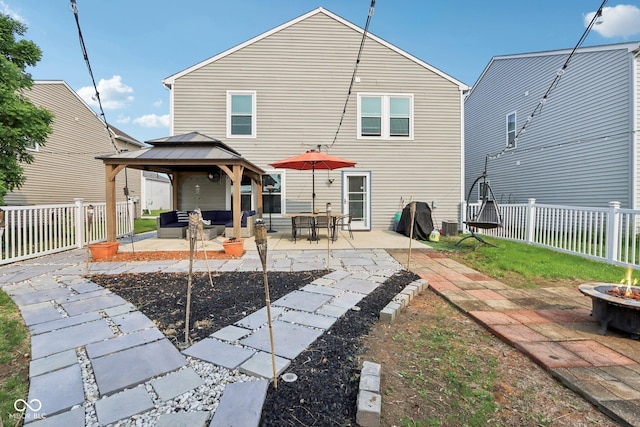 2887 Ludwig Dr, Indianapolis, IN 46239 - rear view of property featuring a gazebo, a patio, a fenced backyard, and an outdoor living space with a fire pit