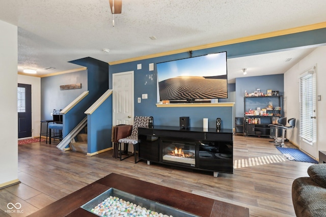 2887 Ludwig Dr, Indianapolis, IN 46239 - living area featuring wood finished floors, a textured ceiling, healthy amount of natural light, crown molding, and stairway