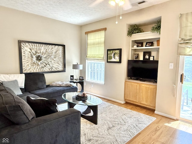 7042 Gavin Dr, Indianapolis, IN 46217 - living room featuring light wood finished floors, ceiling fan, and a textured ceiling