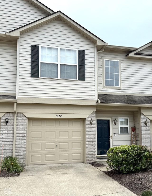 7042 Gavin Dr, Indianapolis, IN 46217 - view of property featuring brick siding, an attached garage, and concrete driveway