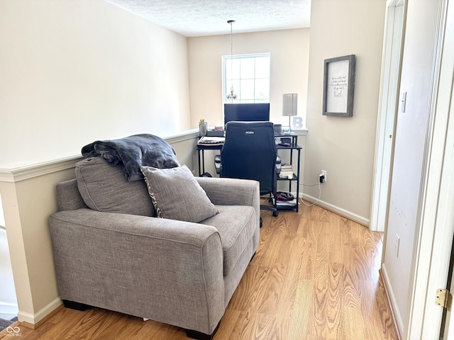 7042 Gavin Dr, Indianapolis, IN 46217 - living room featuring light wood-style floors, a desk, and a textured ceiling