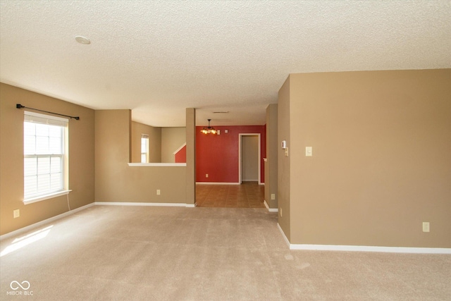12671 Endurance Dr, Fishers, IN 46037 - unfurnished room with light colored carpet, a chandelier, a textured ceiling, and baseboards