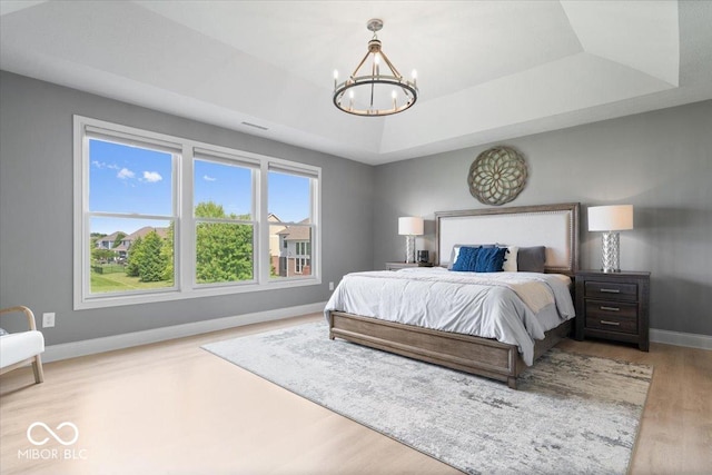 10054 Win Star Way, Fishers, IN 46040 - bedroom featuring a tray ceiling, baseboards, a chandelier, and wood finished floors