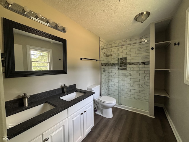 4343 W Fairview Rd, Greenwood, IN 46142 - full bath featuring a textured ceiling, double vanity, a shower stall, and wood finished floors