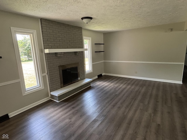 4343 W Fairview Rd, Greenwood, IN 46142 - unfurnished living room featuring a textured ceiling, dark wood finished floors, and a brick fireplace