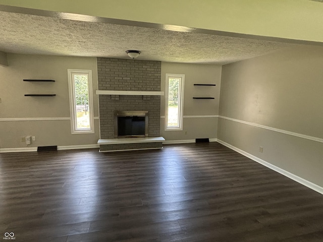 4343 W Fairview Rd, Greenwood, IN 46142 - unfurnished living room with dark wood-style flooring, a textured ceiling, and a brick fireplace