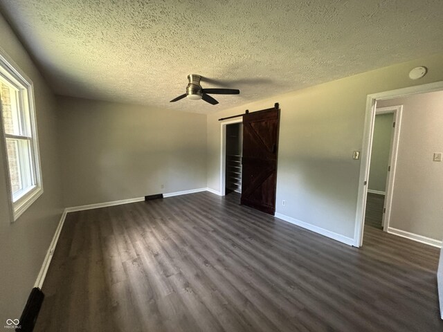 4343 W Fairview Rd, Greenwood, IN 46142 - empty room with a barn door, a textured ceiling, a ceiling fan, dark wood finished floors, and a smoke detector