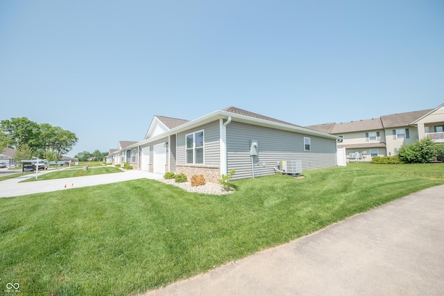 1452 Coen Ct, Columbus, IN 47201 - view of side of property featuring concrete driveway, a lawn, central air condition unit, and a garage