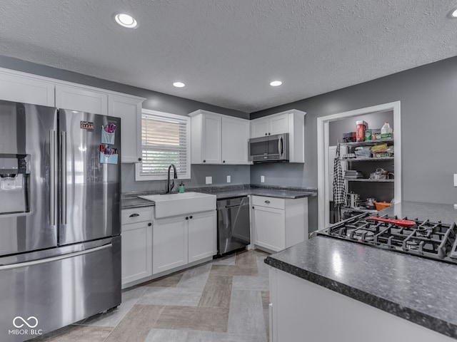 730 N Forsythe St, Franklin, IN 46131 - kitchen with appliances with stainless steel finishes, a sink, dark countertops, white cabinets, and a textured ceiling