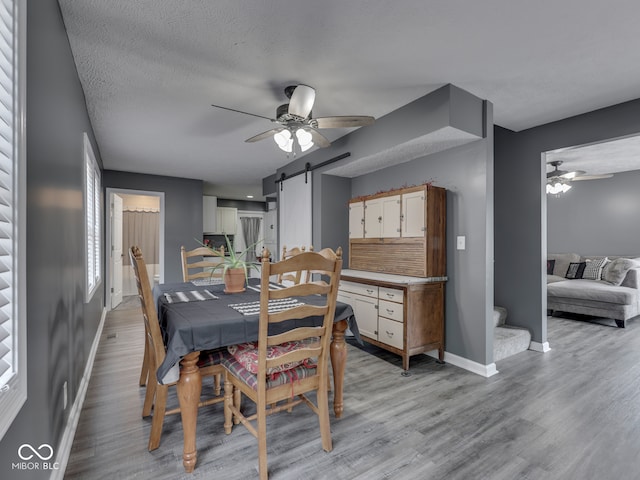 730 N Forsythe St, Franklin, IN 46131 - dining area featuring a ceiling fan, a barn door, baseboards, and light wood-type flooring