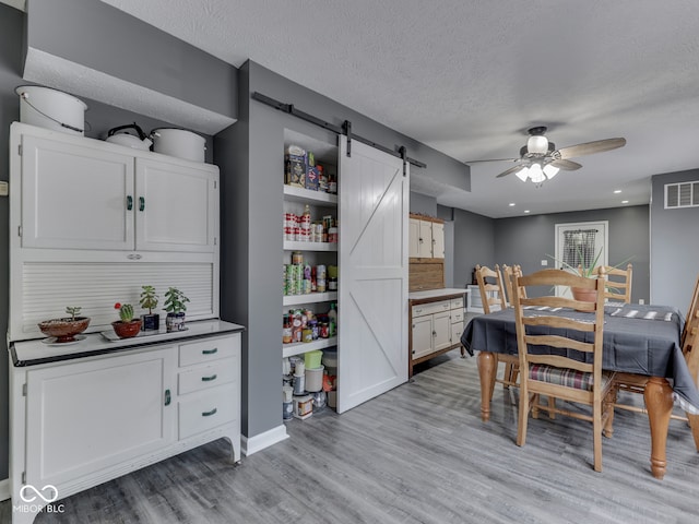 730 N Forsythe St, Franklin, IN 46131 - dining room featuring a barn door, a ceiling fan, light wood-type flooring, a textured ceiling, and recessed lighting